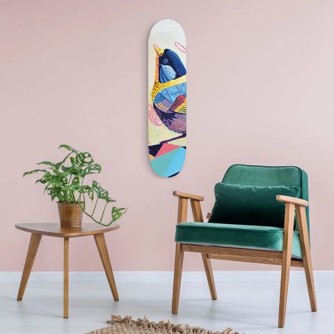Colorful abstract skateboard deck mounted on a pink wall.