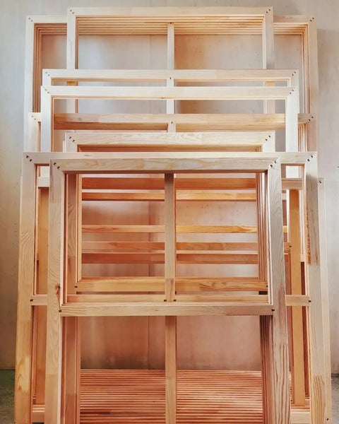 Stack of unfinished wooden window frames or sashes.