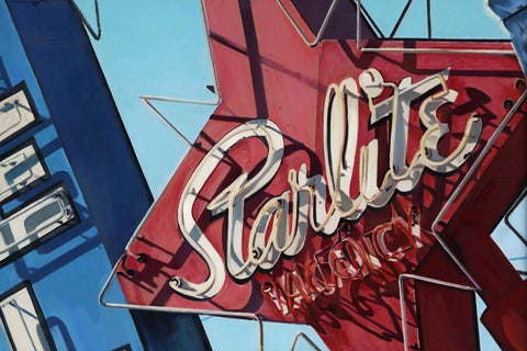 Vintage neon sign for ’Starlite’ in cursive lettering on a red star-shaped background.