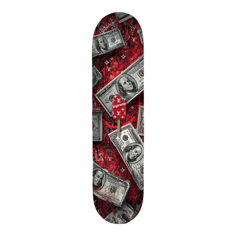 A skateboard deck featuring a vibrant red design with scattered black-and-white $100 bills and repeating louis vuitton monogram patterns, accented by a central supreme logo on a popsicle stick.