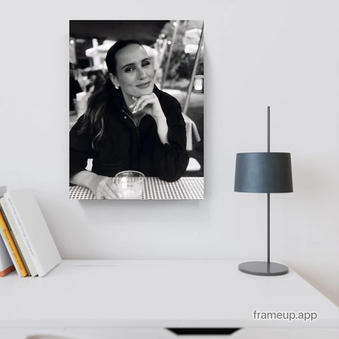 Black-and-white portrait canvas featuring a woman with long dark hair, wearing a black jacket and resting her chin on her hand.