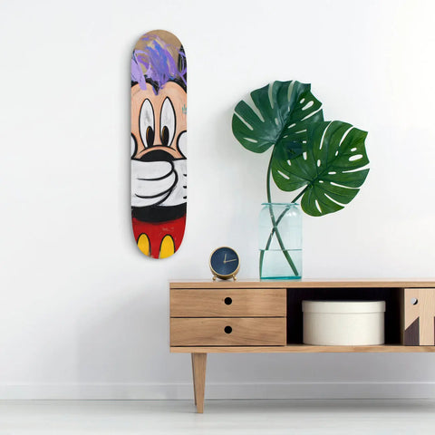 Skateboard deck painted with a colorful cartoon character design.