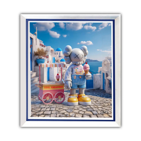 A framed artwork featuring a gray kaws character in blue overalls and yellow shoes holding an ice cream cone, standing beside a pink ’kool kreamery’ cart against a backdrop of white buildings with blue domes under a bright sky.