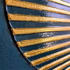 Decorative fan-like object with alternating gold and navy blue ridged segments.