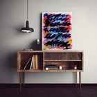 A painting on a wall above a wooden cabinet
