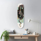 Skateboard deck mounted on a wall featuring a black dragon design against a mint green and white background.