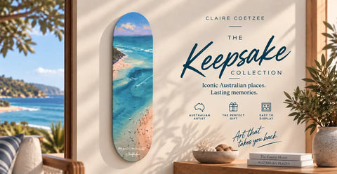 A vibrant, oval-shaped skateboard deck featuring a vivid coastal scene with turquoise waters and sandy shores under a bright blue sky.